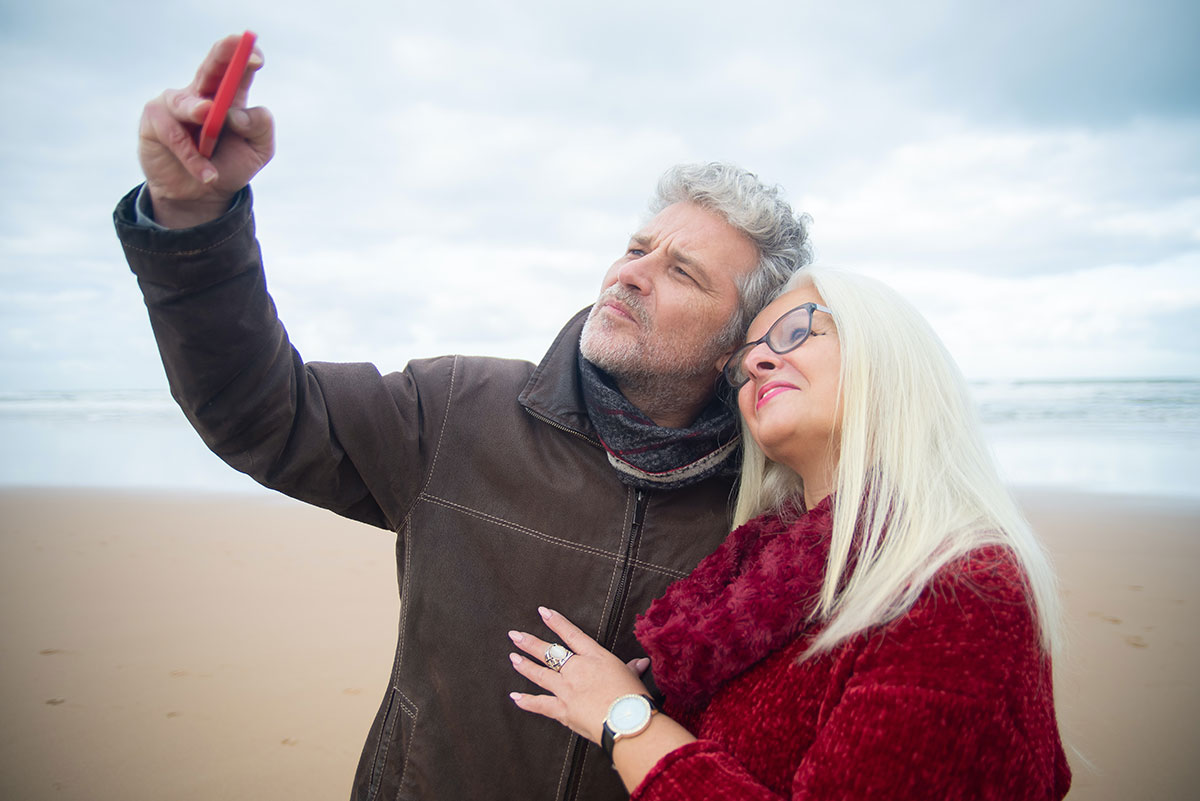 price for bioidentical hormone replacement therapy mature man and woman taking selfie at the beach